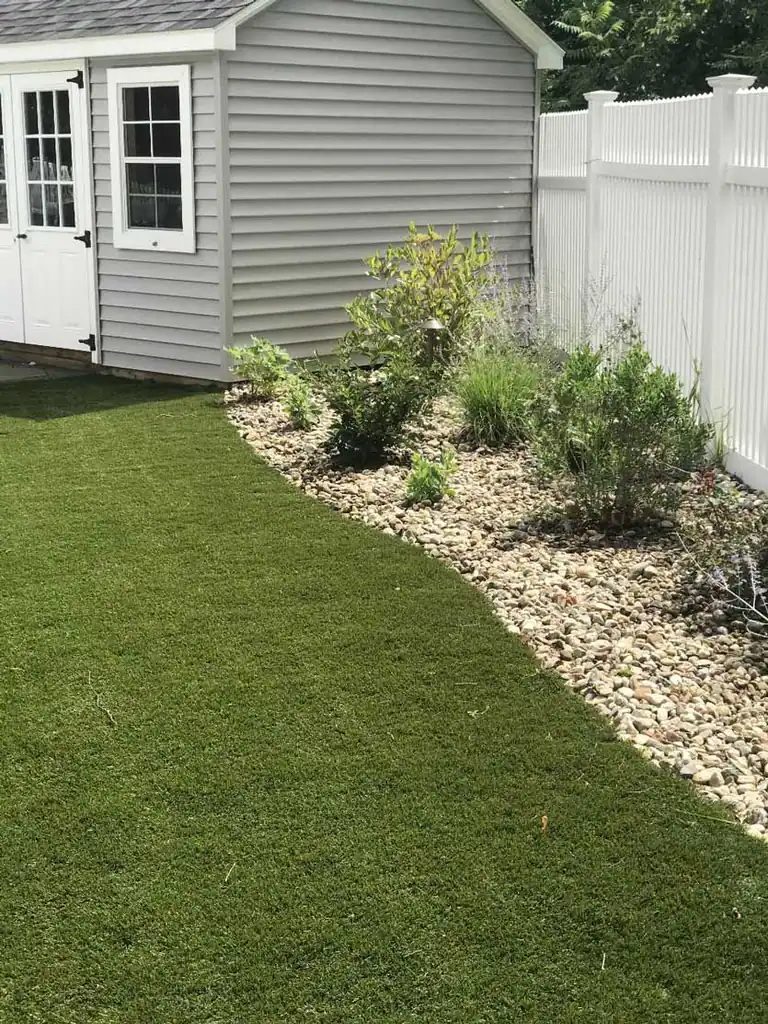 Sod lawn beside a planted stone bed